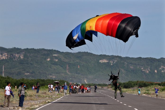Seorang penerjun unjuk kebolehan kemampuan terjun payung pada acara Jogja Air Show 2014 di Pantai